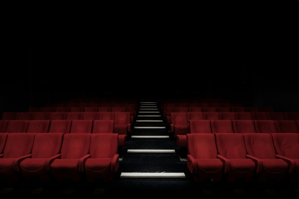An empty theatre auditorium with red velvet seats